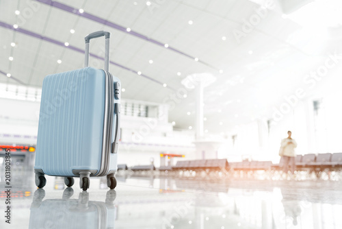 Photos Light blue suitcase positioned upright in airport concourse or railway, concept