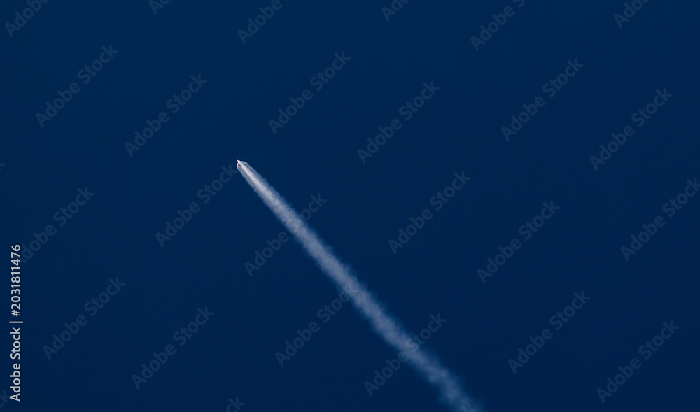 Fototapeta premium Concept aerospace program, Rocket launches into clear blue sky leaving white trail