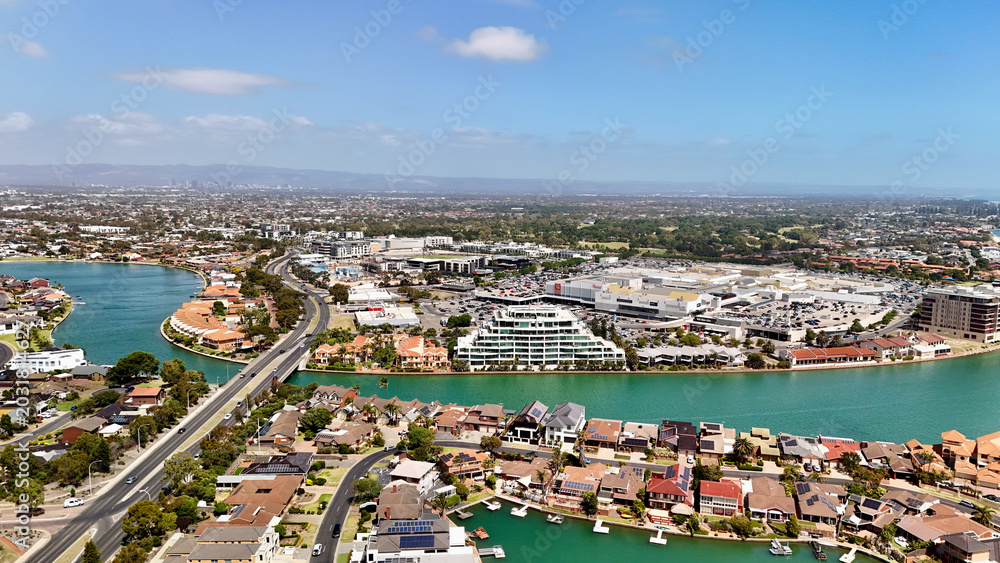 Fototapeta premium West Lakes, South Australia: 4K aerial drone view of coastal suburb, shore, canal waterways, residential housing, marina areas, bridges and urban waterfront landscape, Grange Beach, Tennyson Beach
