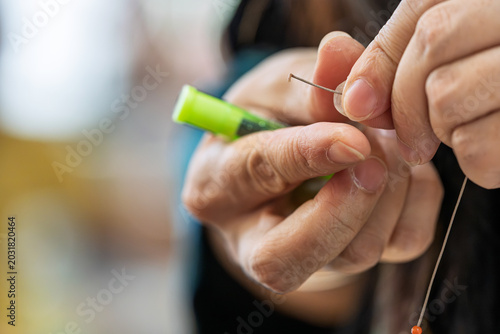 Obraz na płótnie Artisan hand stringing beads to make bracelets closeup