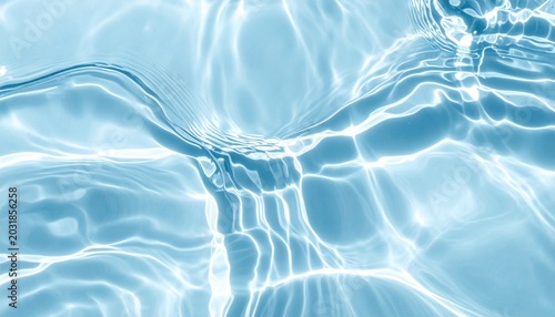 Bright ripples of sunlight dance on a serene blue water surface, creating a soothing visual texture