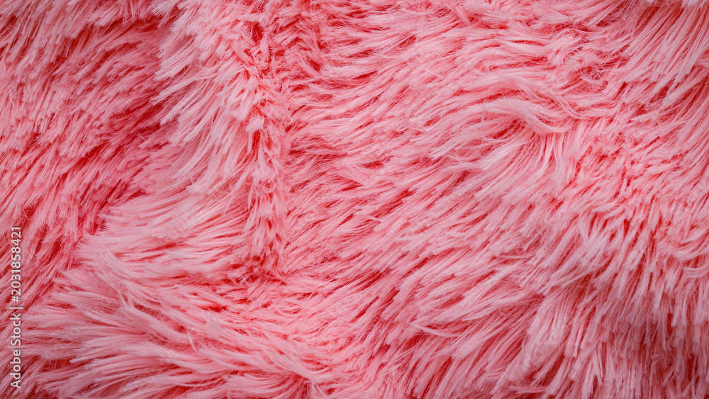 Fototapeta premium Soft pink fluffy fabric spreads across a surface in a bright space with natural light during daytime