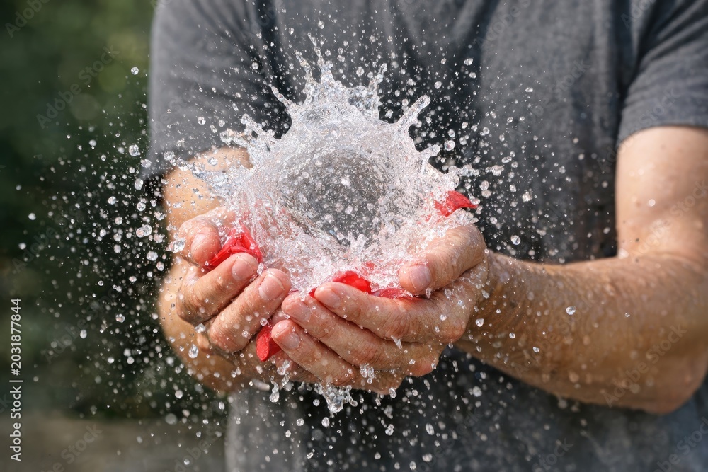 Fototapeta premium A person holds a small amount of water in their hand, ready to use
