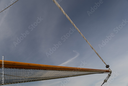 Bild auf Leinwand Bowsprit and furled headsail against blue sky on a classic sailing vessel, geome