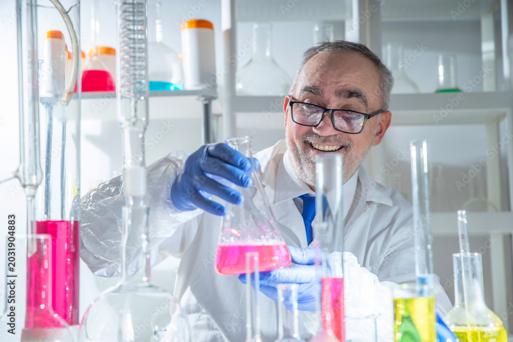 Fototapeta premium Joyful professional male scientist celebrating a successful laboratory experiment and scientific discovery, showing confidence, optimism and research achievement.