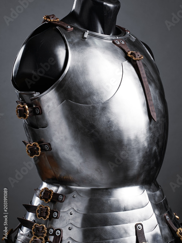 Canvastavla A detailed view of a medieval-style polished armor breastplate, showcasing gleaming steel and leather fastenings on a dark background, symbolizing historical reenactment, chivalry, and craftsmanship