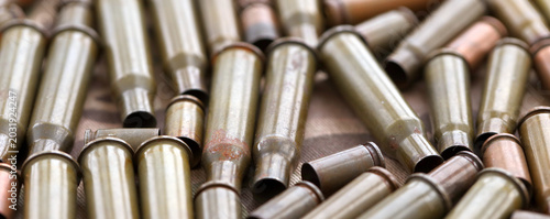 Obraz na płótnie Big amount of shells cartridges from assault rifle bullets on old camouflage fab