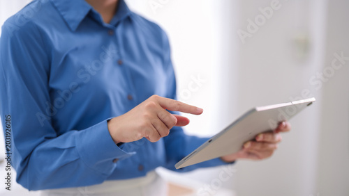 business professional using digital tablet touchscreen technology reviewing data report working modern office environment corporate workplace productivity