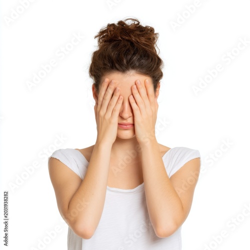 Young woman hiding face with hands, expressing emotions of stress, anxiety, and frustration on isolated white background