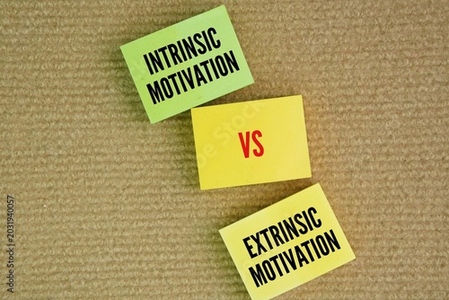 Paper with the words Intrinsic Vs Extrinsic Motivation. Intrinsic and extrinsic motivation refer to the forces that drive behavior. Internal motivation arises from within
