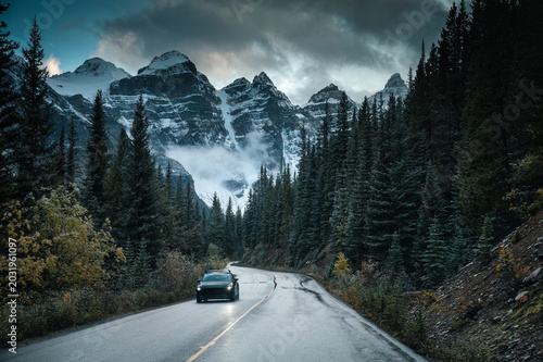 Scenic mountain road through pine forest toword Canadian Rockies Peak in Banff national park, Canada