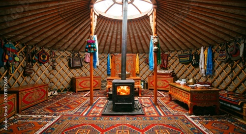 Traditional Mongolian ger yurt interior with burning iron stove colorful kilim carpets and painted wooden furniture nomadic culture