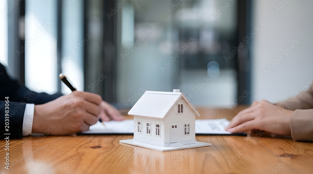 Fototapeta premium Miniature house model on wooden table during real estate transaction