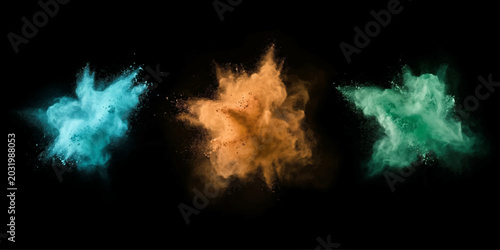 Fotografie Three vibrant explosions of colored powder – teal, orange, and green – burst dramatically against a stark black background, creating a dynamic and abstract visual spectacle