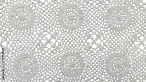 Background view of an elegant white vintage crochet lace textile with intricate handmade needlework, a full frame background texture.