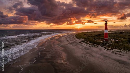 Panoramic sunset at beach with red and white lighthouse on Sylt North Sea coast Germany