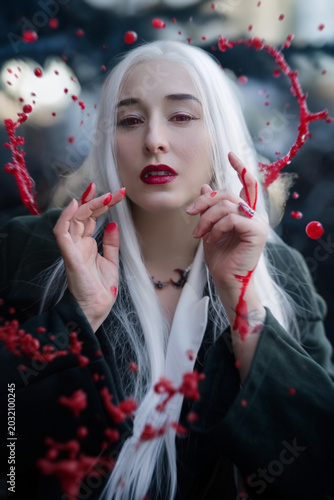 A gothic vampire with red eyes and blood splatter. Portrait at night.