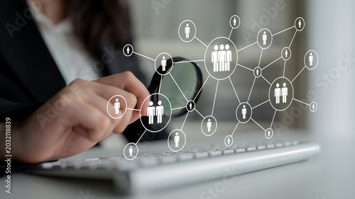 A business professional engages with digital networking concepts on a computer keyboard, showcasing the intersection of technology and interpersonal connections in the workplace. Ledger