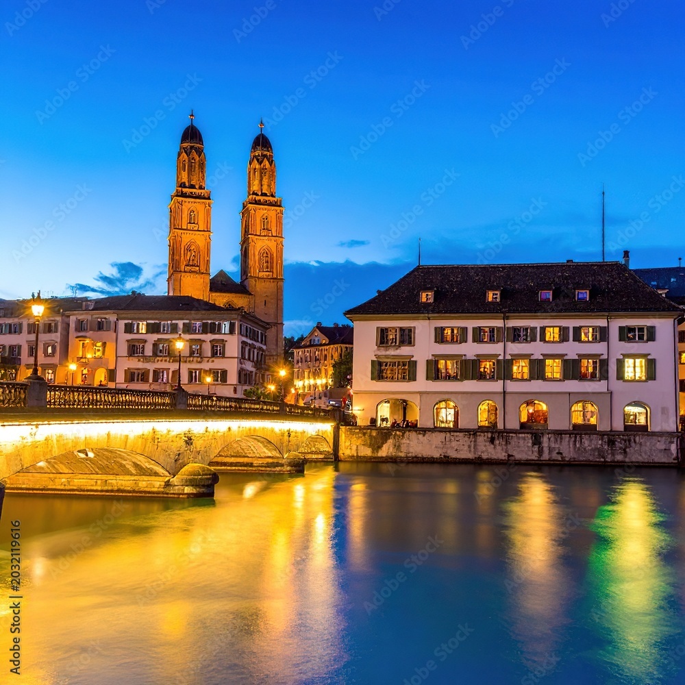 Obraz premium Nighttime cityscape with illuminated buildings river.
