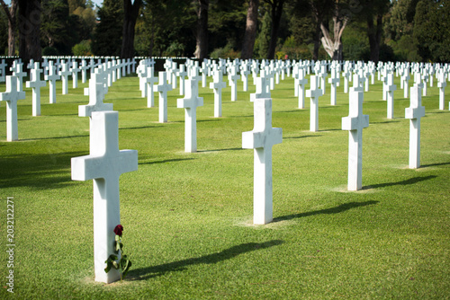 Foto Rows of white cross headstones on green grass lawn at a historic WWII military g