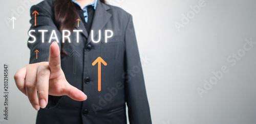 Schilderij op canvas Businesswoman pressing startup button with upward arrows symbolizing business gr