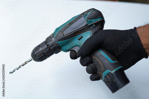 Electronic rechargeable drill in hand on white background. closeup image