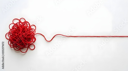 A tangled mess of red yarn or string on the left side that transitions into a single straight line extending to the right against a plain white background, representing complexity