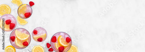 Sweet summer pink lemonade corner border. Top view on a white marble banner background with copy space.