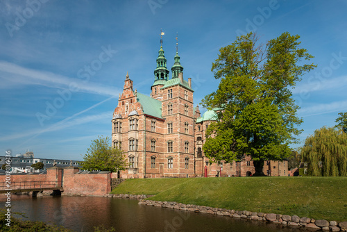 Rosenborg Castle in Copenhagen, Denmark. Historic renaissance palace in the King's Garden on a bright sunny spring day with green trees and blue sky.