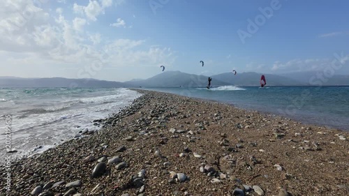Kitesurfers Flying Above Narrow Pebble Beach on Greek Island Shore