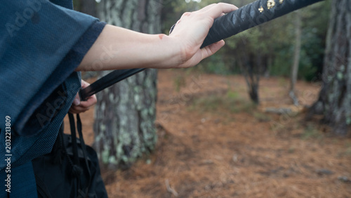 Close-up of a samurai drawing his katana in a forest setting, capturing traditional Japanese swordsmanship and martial discipline. Cinematic scene emphasizing precision, focus, and historical warrior 