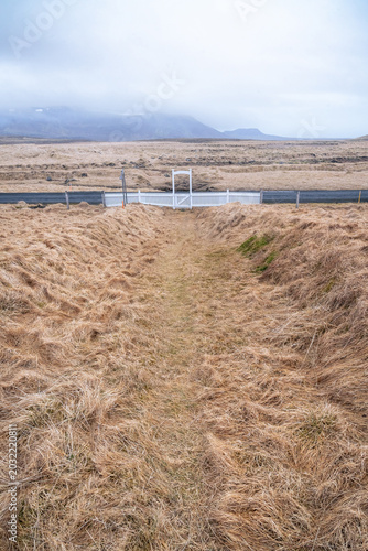 White gate and fence on the road to Krysuvikurkirkja on the Reykjanes Peninsula in Iceland on a March day.