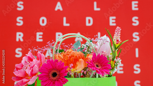 Schilderij op canvas Colorful flowers in a shopping bag during a sale event in a retail store