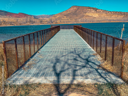 Foto Newton Lake dock pier in Wyoming looks out at water & mountains & red butte beyond