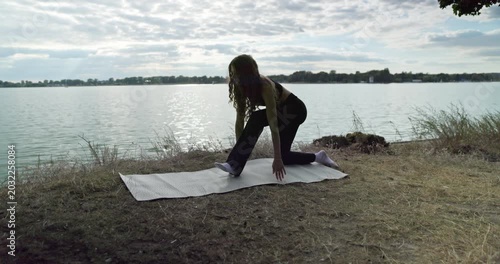 Engaging in a Peaceful Outdoor Yoga Practice by the Tranquil and Refreshing Water Body