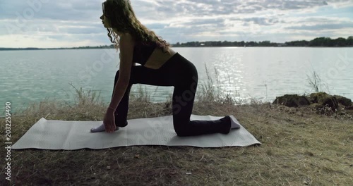 Practicing Yoga by the serene Lake Focusing on Stretching and Meditation for relaxation