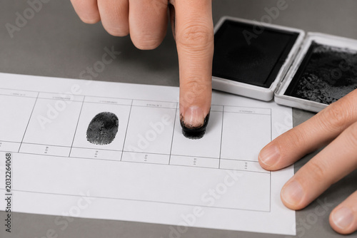 Fingerprint collection process on an ink fingerprint card for biometric identification and forensic investigation, close-up view