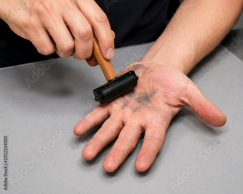 Fingerprint collection process on an ink fingerprint card for biometric identification and forensic investigation, close-up view