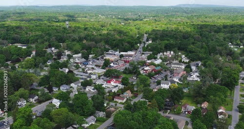 Red Hook, NY, USA - 05-20-2026  Aerial video of Red Hook, NY, a small upstate town nestled within a vast expanse of lush green forest under a partly cloudy sky.