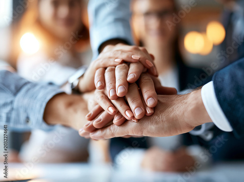 Hands come together in a group meeting to show support during a business discussion at a work event in a city