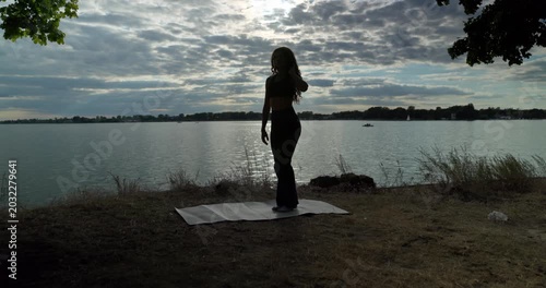 Engaging in a Silhouette Yoga Practice by the Water during a Beautiful Sunset Experience