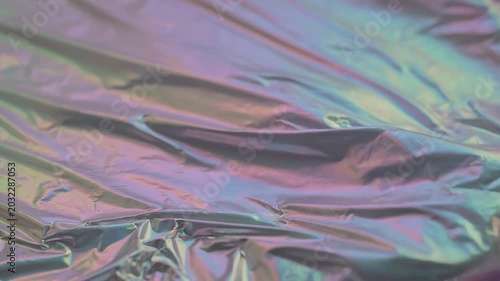 Iridescent fabric shimmers with crinkled texture in close-up view