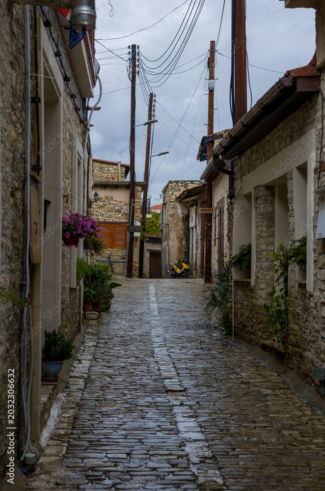 Fototapeta premium Narrow cobblestone alley with rustic stone walls and wooden doors