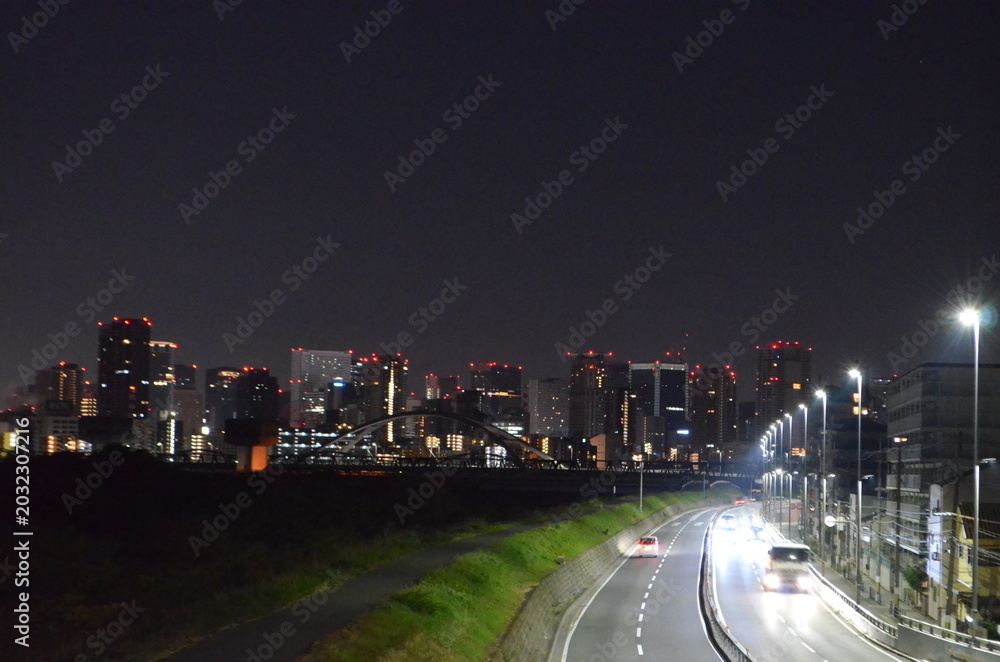 Obraz premium Beautiful night view of Osaka city skyline with illuminated skyscrapers reflecting in the Yodo river, Japan