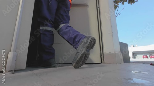 Construction Worker Walking Into Restricted Industrial Area From Ground Perspective
