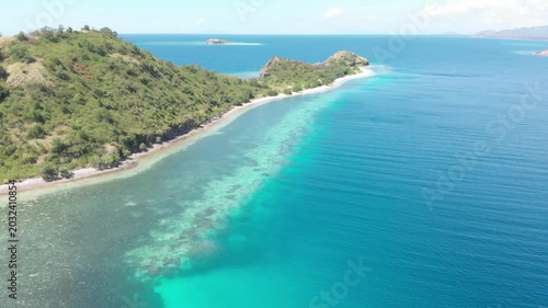 Panoramic aerial view of the 17 Islands Marine Park near Riung, Flores, Indonesia, featuring turquoise coral reefs, tropical islets, and deep blue ocean under a bright sky