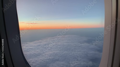 View of clouds at sunrise from an airplane window
