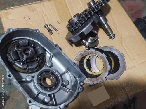 Motorcycle engine repair with disassembled clutch parts, motorcycle maintenance in the garage,