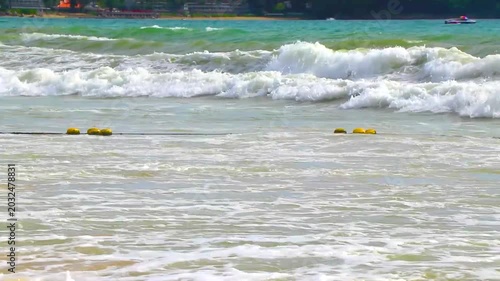 Strong tropical surf on sandy beach with crystal clear water Thailand.