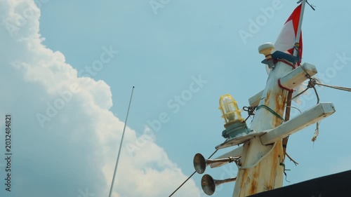 Waving Indonesian flag on a ship mast against cloudy sky